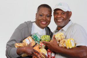 owners Jana and Marc holding bags of popcorn